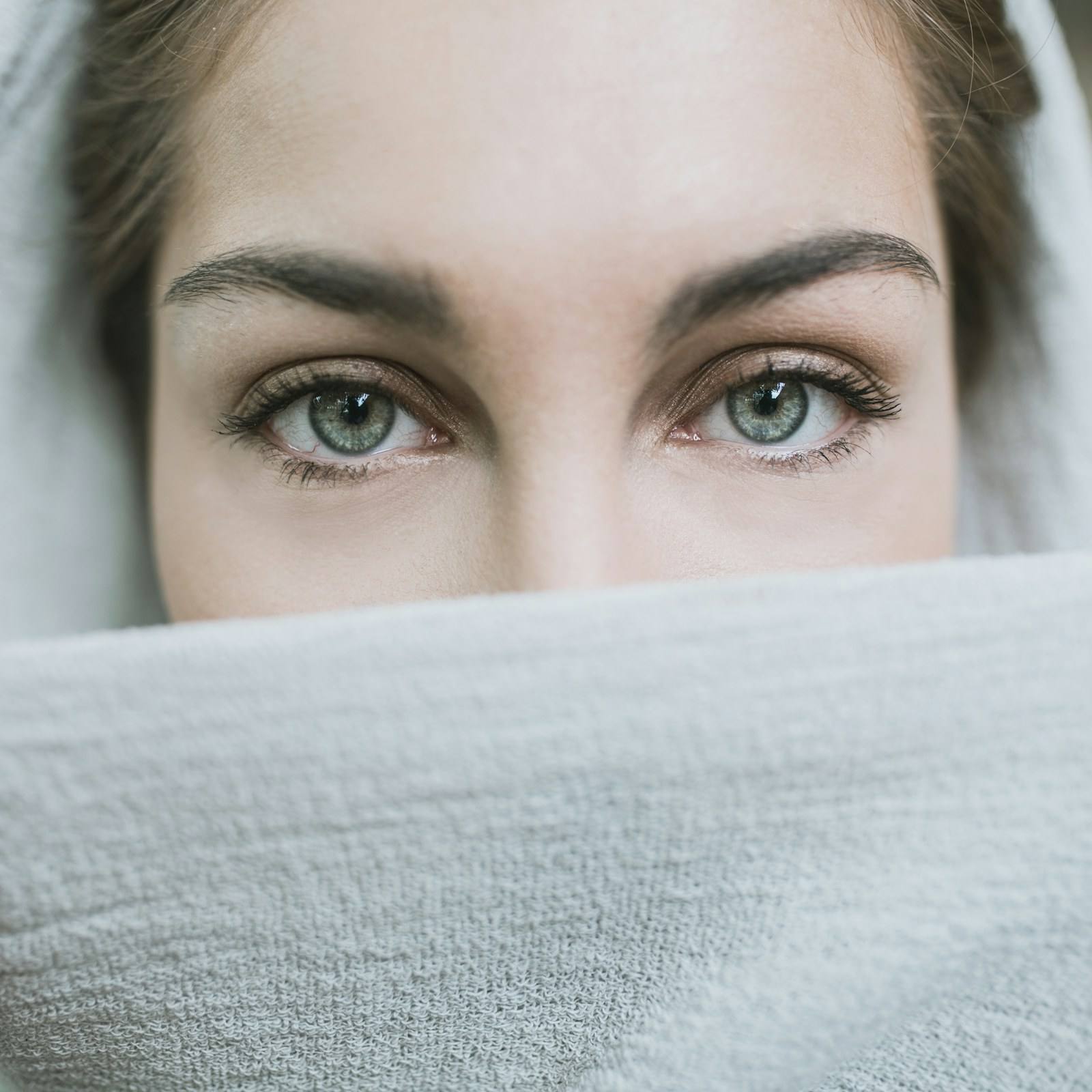 Close-up of a woman’s eyes above a soft white towel